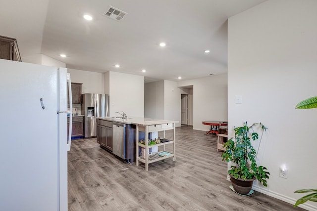 kitchen with light countertops, light wood-style floors, visible vents, and stainless steel appliances