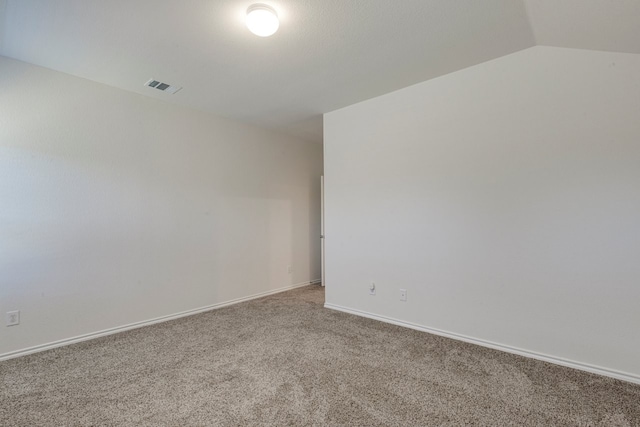 unfurnished room with visible vents, carpet flooring, baseboards, and lofted ceiling