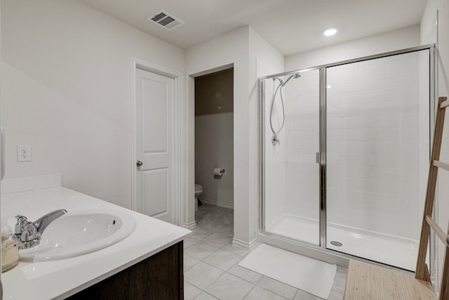 bathroom with vanity, visible vents, a shower stall, tile patterned floors, and toilet