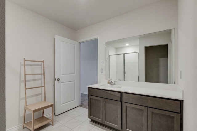 bathroom with tile patterned flooring, a stall shower, and vanity