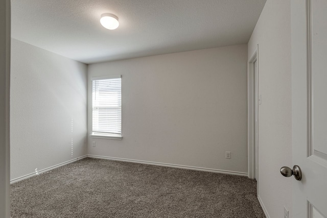 spare room with baseboards, carpet floors, and a textured ceiling