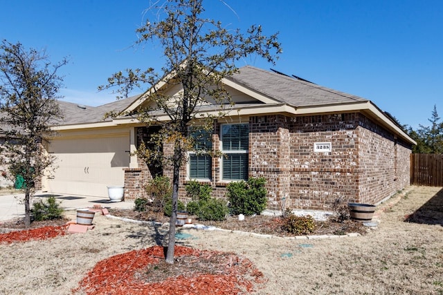 view of front of house with an attached garage, fence, brick siding, and driveway