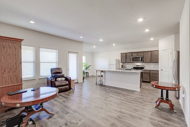 living area with recessed lighting and light wood-style flooring