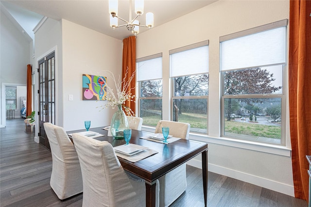 dining space with dark hardwood / wood-style flooring and a notable chandelier