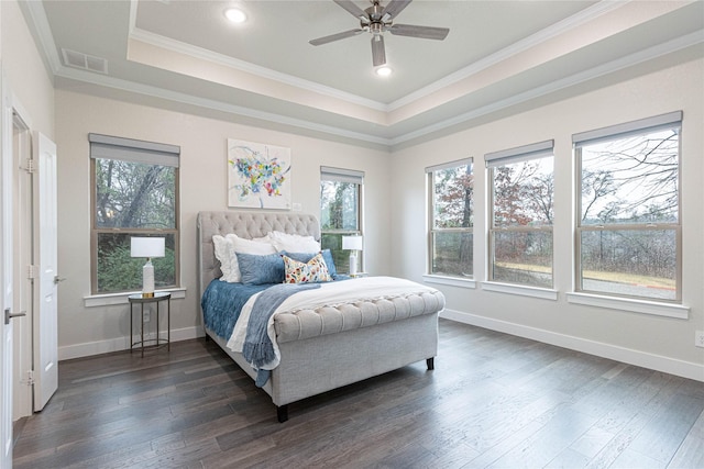 bedroom with dark wood-type flooring, crown molding, and a raised ceiling