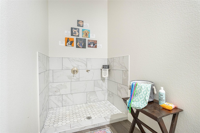 bathroom featuring hardwood / wood-style flooring and tiled shower