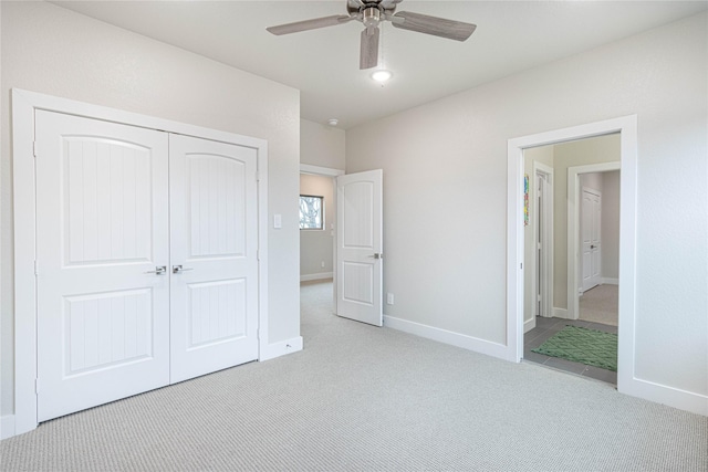 unfurnished bedroom featuring light colored carpet, ceiling fan, and a closet