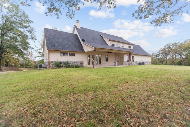 rear view of property featuring a yard, central AC unit, and a patio area