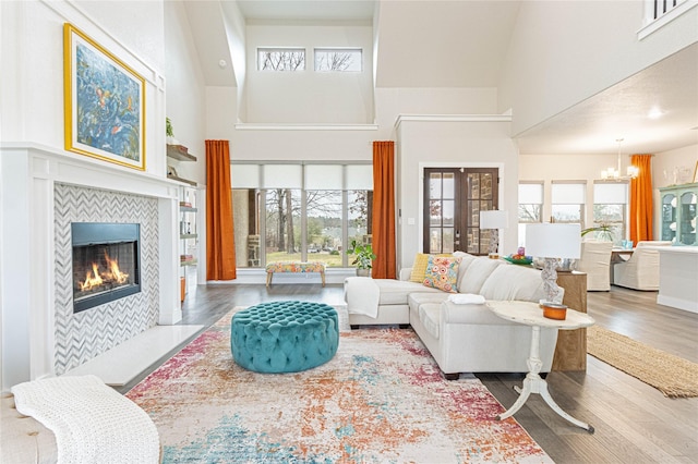 living room featuring plenty of natural light, a tile fireplace, and a high ceiling