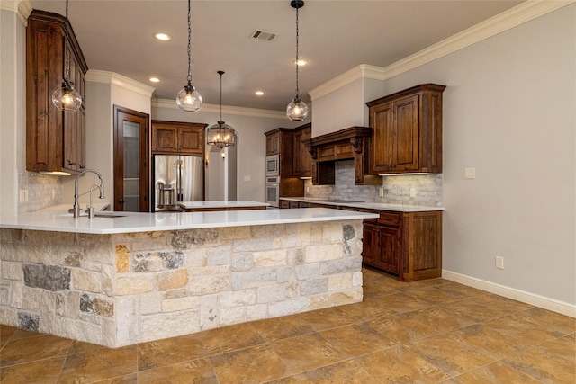 kitchen featuring pendant lighting, sink, crown molding, stainless steel appliances, and tasteful backsplash