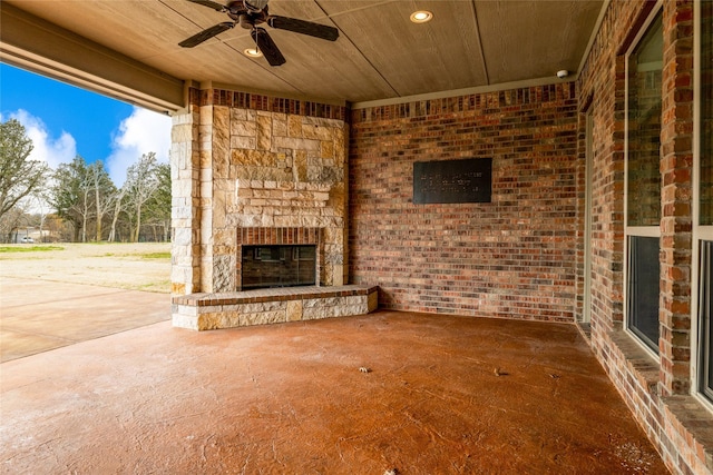 view of patio / terrace featuring ceiling fan and an outdoor stone fireplace