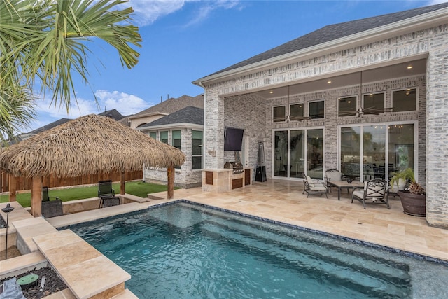 view of swimming pool with area for grilling, a gazebo, exterior kitchen, a fenced in pool, and a patio area