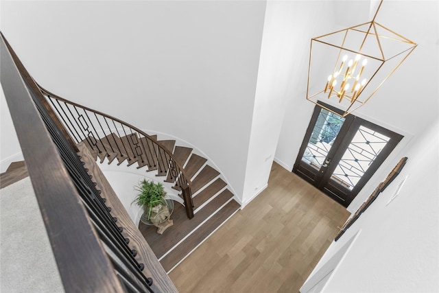 entryway featuring a notable chandelier, a high ceiling, french doors, and wood-type flooring