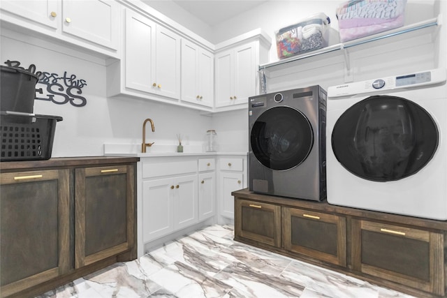 laundry area with cabinets, washer and dryer, and sink