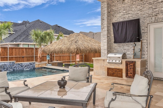 exterior space with a fenced in pool, pool water feature, a grill, and exterior kitchen