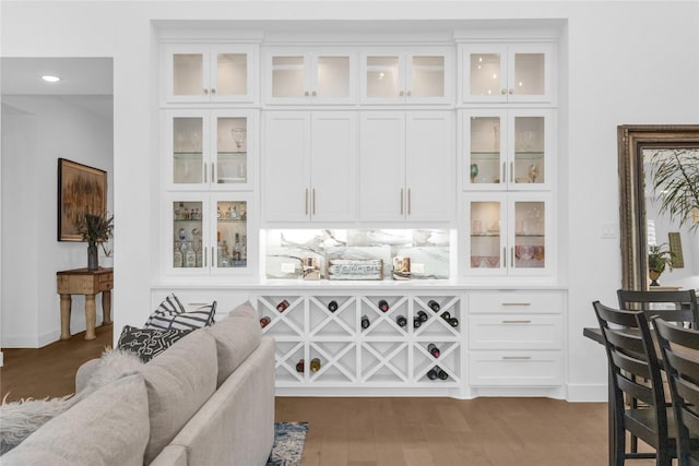 bar featuring white cabinets and hardwood / wood-style flooring