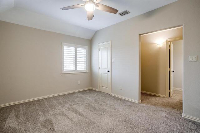 unfurnished bedroom with ceiling fan, vaulted ceiling, and light carpet