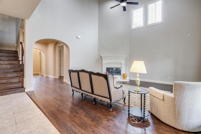 living room featuring ceiling fan, hardwood / wood-style floors, and a high ceiling