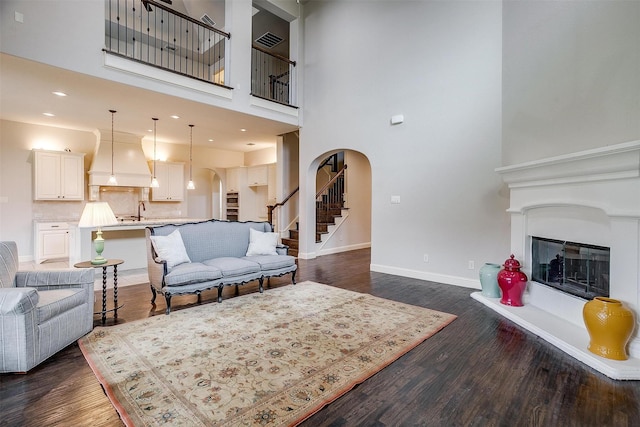 living room with sink, dark hardwood / wood-style floors, and a high ceiling