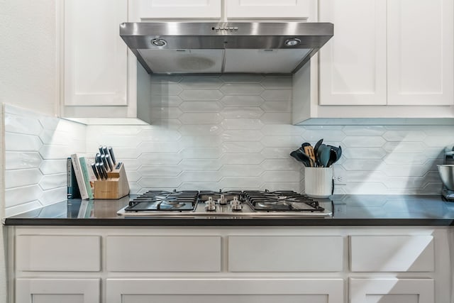 kitchen featuring backsplash, stainless steel gas stovetop, and white cabinets