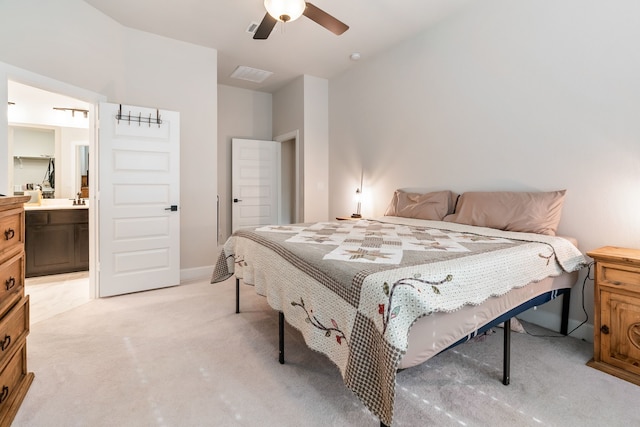 carpeted bedroom with ceiling fan and ensuite bath