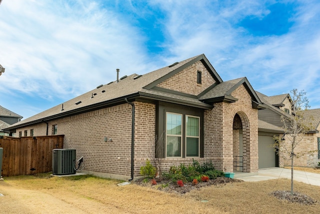 view of home's exterior featuring a garage, cooling unit, and a lawn