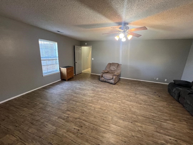 unfurnished room with ceiling fan, dark hardwood / wood-style flooring, and a textured ceiling