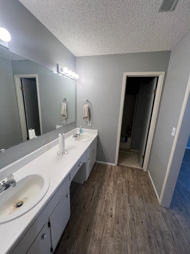 bathroom with vanity, hardwood / wood-style floors, and a textured ceiling