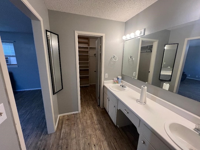 bathroom with vanity, hardwood / wood-style floors, and a textured ceiling