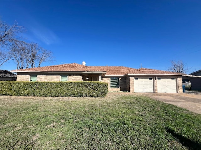 ranch-style home featuring a garage and a front lawn