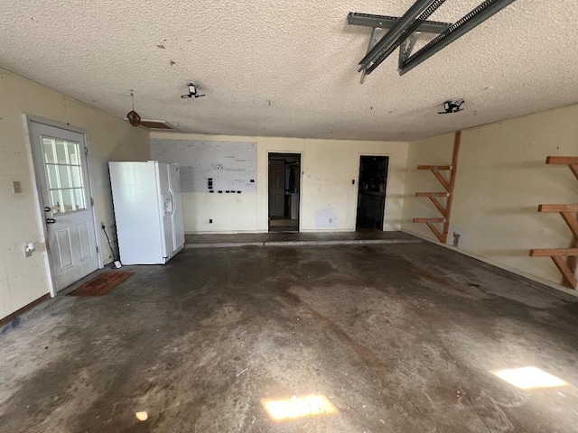 garage featuring white refrigerator with ice dispenser