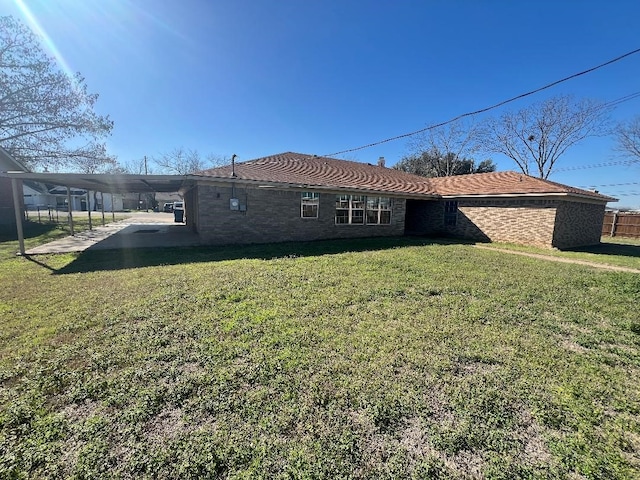 rear view of property with a yard and a carport