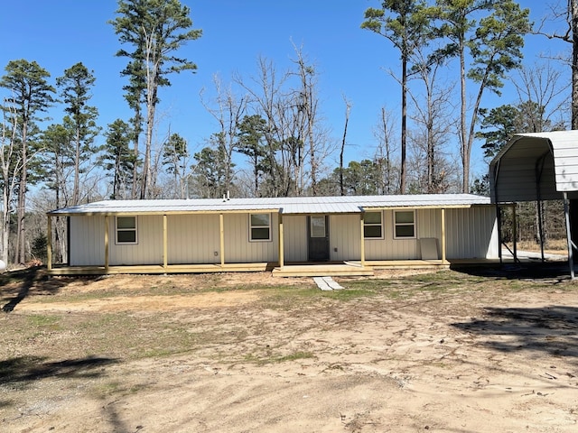 rear view of house with a detached carport and metal roof