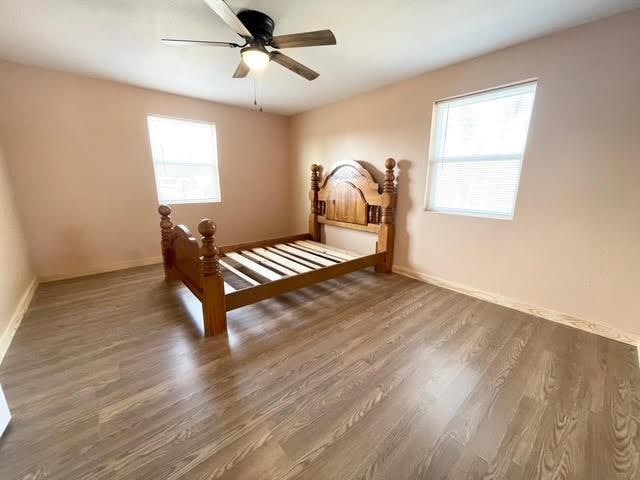 bedroom with dark hardwood / wood-style flooring and ceiling fan