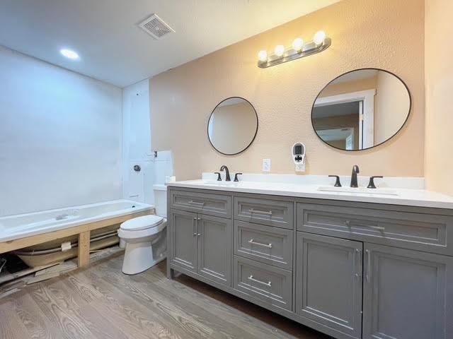 bathroom with vanity, toilet, and hardwood / wood-style floors