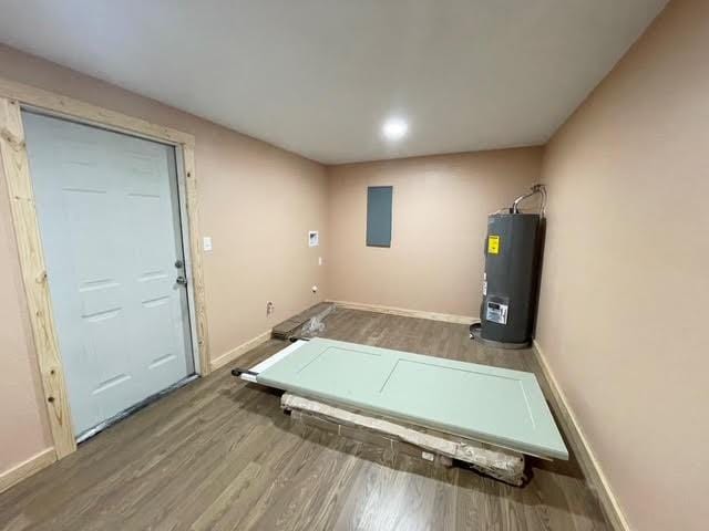 interior space with baseboards, wood finished floors, and water heater