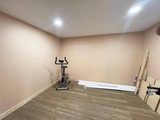 workout room featuring baseboards and wood finished floors