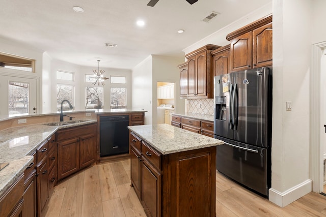 kitchen featuring decorative light fixtures, black dishwasher, sink, a center island, and stainless steel refrigerator with ice dispenser