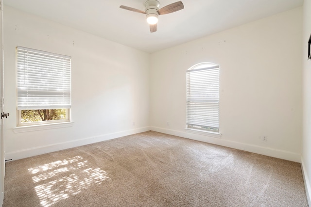 carpeted spare room with ceiling fan