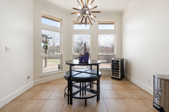 dining space with ornamental molding, beverage cooler, light tile patterned floors, and plenty of natural light