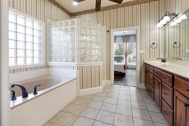 bathroom featuring a notable chandelier, vanity, a bathing tub, and tile patterned floors