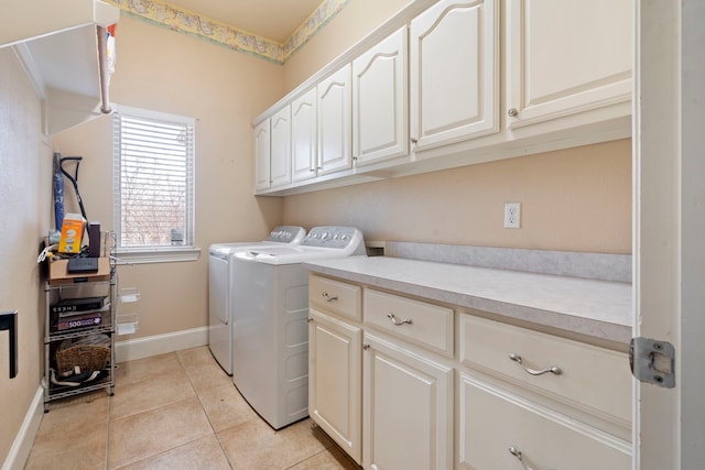 washroom featuring cabinets, washing machine and dryer, and light tile patterned flooring