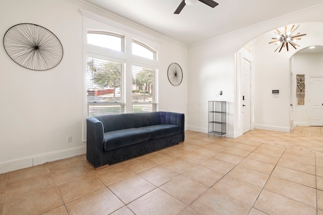 living area with light tile patterned floors, crown molding, and ceiling fan with notable chandelier