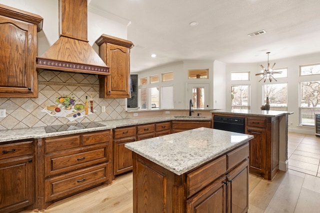 kitchen featuring a kitchen island, sink, hanging light fixtures, black appliances, and custom range hood