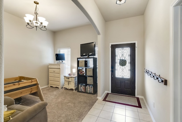 carpeted foyer featuring an inviting chandelier