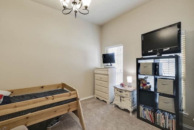 bedroom with an inviting chandelier and light colored carpet