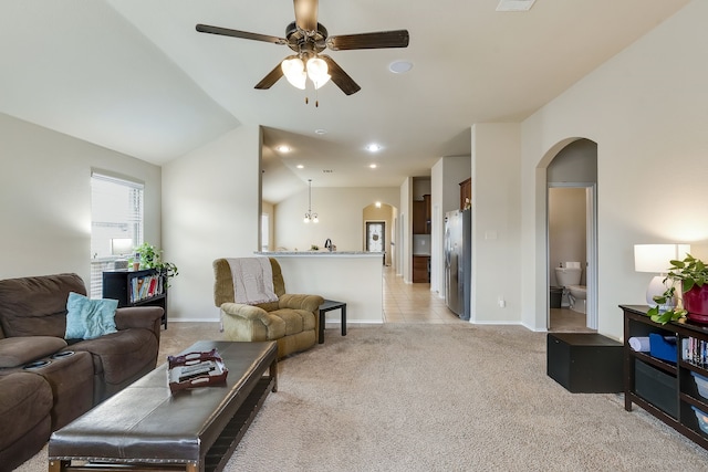 carpeted living room with ceiling fan and lofted ceiling