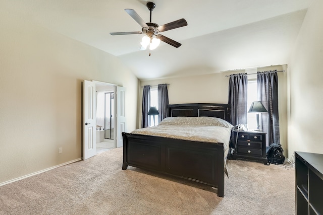 carpeted bedroom with lofted ceiling, multiple windows, ceiling fan, and ensuite bathroom