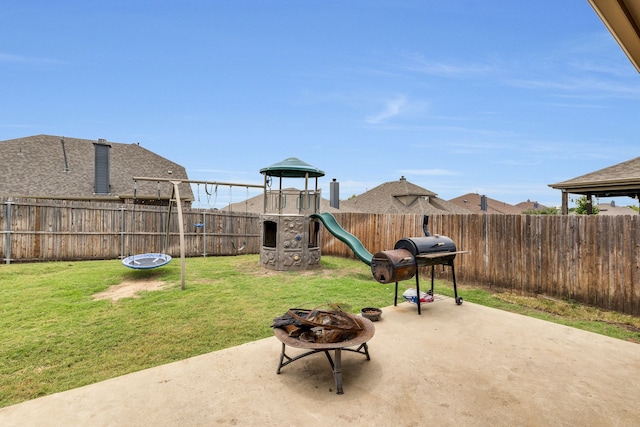 view of patio / terrace with grilling area, an outdoor fire pit, and a playground