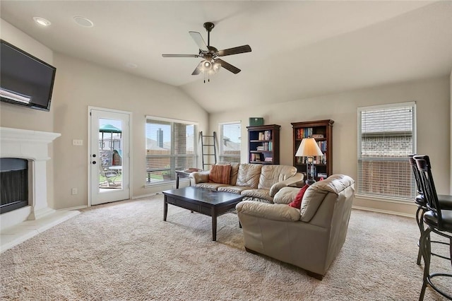 carpeted living room featuring a fireplace, ceiling fan, and vaulted ceiling